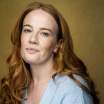 Keeley smiling with her long red hair down