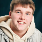A headshot of Zac smiling