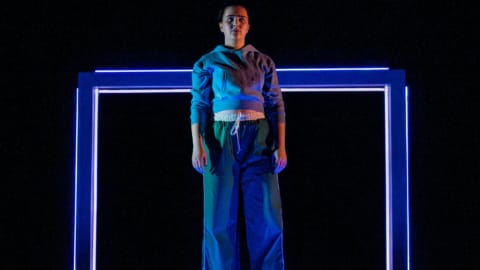 A woman stood on a desk with neon backdrop